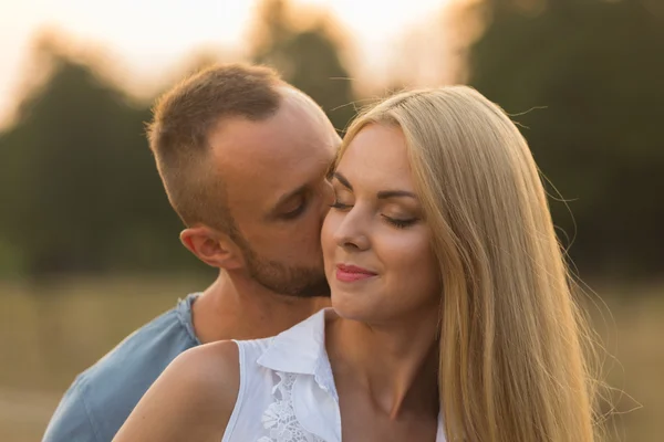 L'uomo e la donna si abbracciano teneramente sul campo. Amore e sentimenti sinceri . — Foto Stock