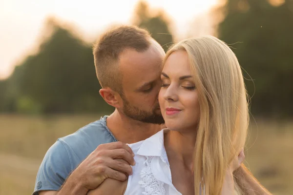 L'homme et la femme s'embrassent tendrement sur le terrain. Amour et sentiments sincères . — Photo