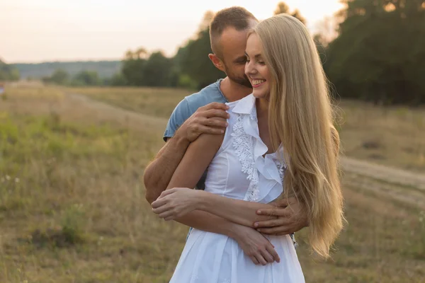 Muž a žena něžně obejmout v poli. Láska a upřímné pocity. — Stock fotografie