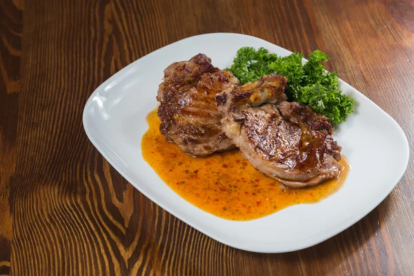 Dana rosto bir tabakta sebze ile bir tavada.