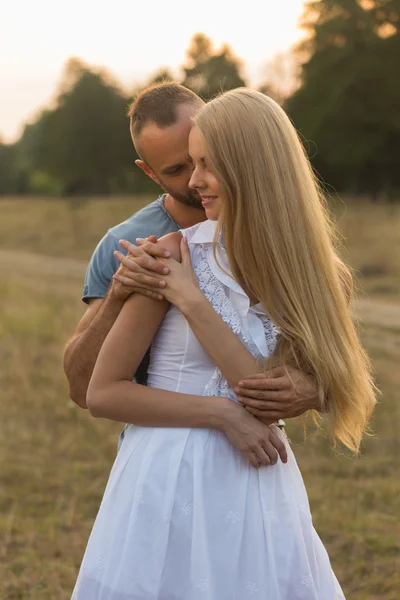 L'uomo e la donna si abbracciano teneramente sul campo. Amore e sentimenti sinceri . — Foto Stock