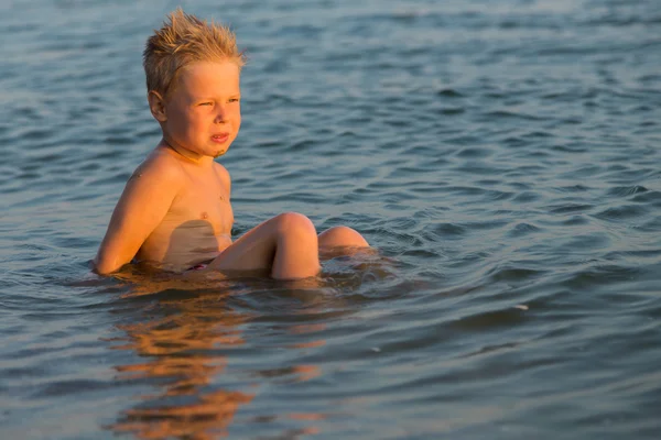 Ragazzo 5 anni a giocare in mare. Un ragazzo nuota nel mare . — Foto Stock