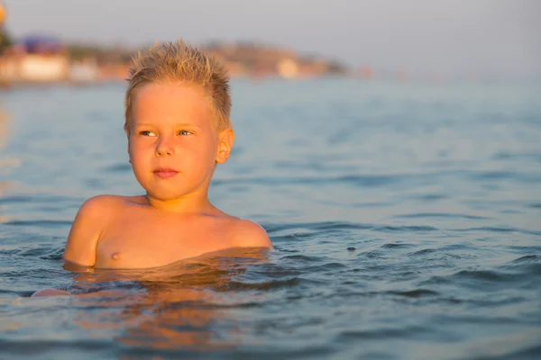 Ragazzo 5 anni a giocare in mare. Un ragazzo nuota nel mare . — Foto Stock