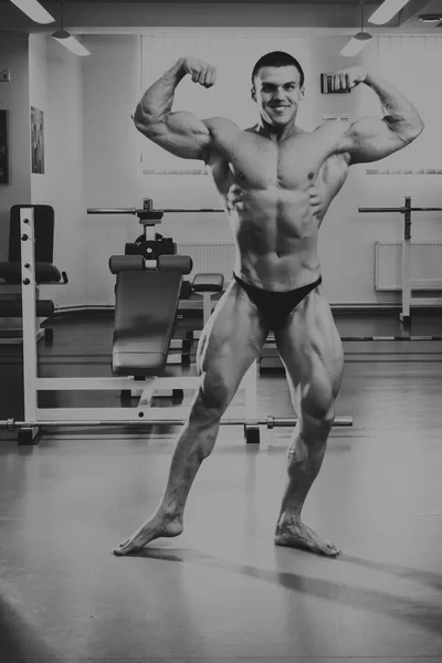 Knappe, atletische, zelfverzekerd man in de sportschool. Bodybuilding pose — Stockfoto