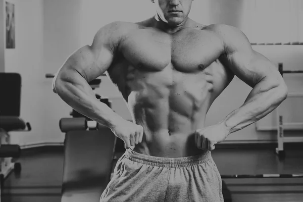 Homem bonito, atlético e confiante no ginásio. postura de musculação — Fotografia de Stock