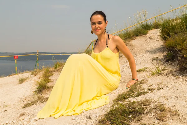 Προσωπογραφία του κοριτσιού με φόντο ένα πανέμορφο φυσικό τοπίο. Κορίτσι στη φύση με ένα όμορφο κίτρινο φόρεμα. — Φωτογραφία Αρχείου