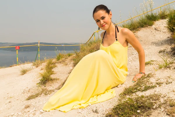 Ritratto della ragazza sullo sfondo di un bellissimo paesaggio naturale. Ragazza in natura in un bellissimo vestito giallo . — Foto Stock