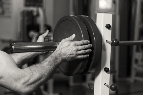 Entraînement de force avec haltères. Husky tient un grand haltère à la main. Sport, musculation, mode de vie sain . — Photo