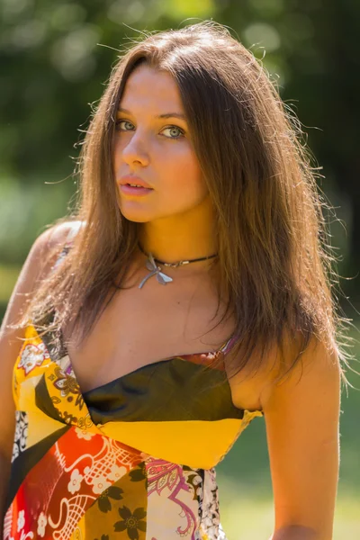 Μια νέα και ελκυστική κοπέλα όμορφο καλοκαίρι φόρεμα μέση της ηλιόλουστη λιβάδια. Χαρούμενο κορίτσι, λουσμένο στις ζεστές ακτίνες του καλοκαιρινού ήλιου. Όμορφη εικόνα της μια ανέμελη κορίτσι. — Φωτογραφία Αρχείου
