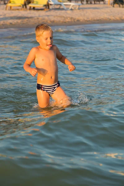 Junge 5 Jahre spielen im Meer. Ein Junge schwimmt im Meer. — Stockfoto