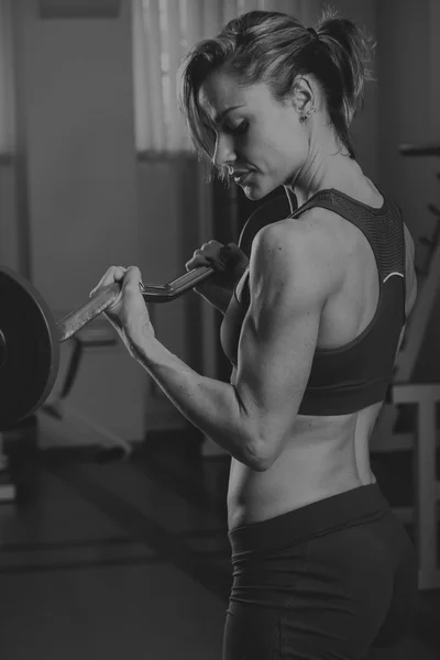 Chica bombea los principales grupos musculares en el gimnasio. Entrenamiento de fuerza. Aptitud femenina. Chica fuerte . — Foto de Stock