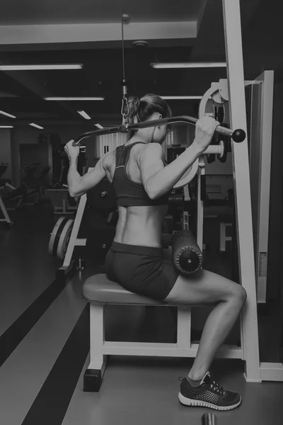 Fille pompe les principaux groupes musculaires dans la salle de gym. Entraînement de force. Condition physique féminine. Forte fille . — Photo