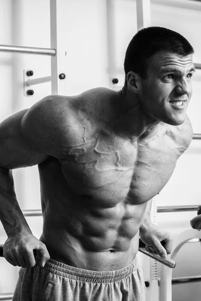 Muscular man working out with weights in gym. Man makes exercises. — Stock Photo, Image