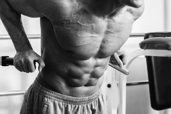 Hombre musculoso haciendo ejercicio con pesas en el gimnasio. El hombre hace ejercicios . —  Fotos de Stock