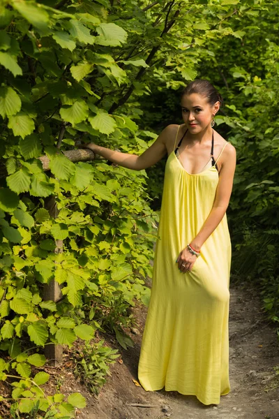 Portret van het meisje tegen de achtergrond van een prachtig natuurlandschap. Meisje in de natuur in een mooie gele jurk. — Stockfoto