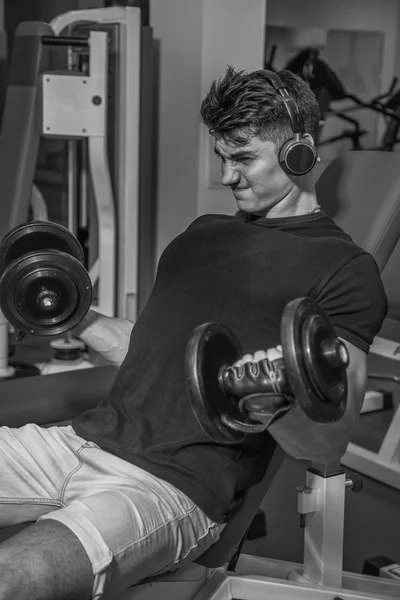 Bodybuilder trainiert im Fitnessstudio mit Kurzhanteln. Arbeit an den Händen sagen Muskeln. anstrengende Trainingseinheiten zu Ende. Fotos für Sportzeitschriften und Webseiten. — Stockfoto