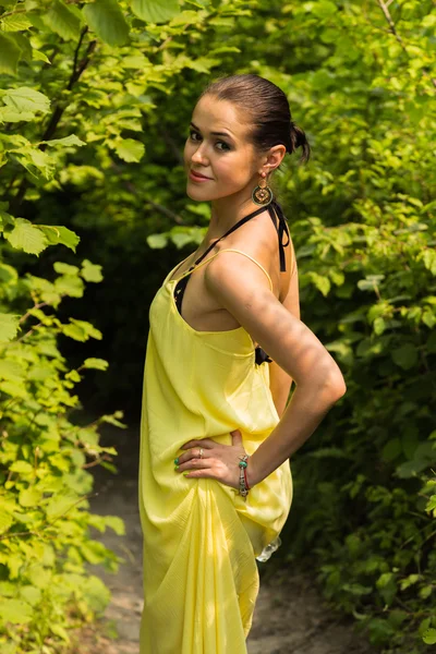 Retrato da menina contra o pano de fundo de uma bela paisagem natural. Menina na natureza em um belo vestido amarelo . — Fotografia de Stock