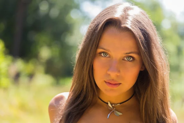 Uma menina jovem e atraente em belo vestido de verão no meio de prados ensolarados. Menina alegre se aquecendo nos raios quentes do sol de verão. Imagem bonita de uma menina despreocupada . — Fotografia de Stock