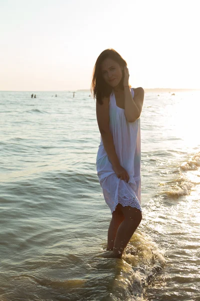 Молода красива дівчина в білій сукні на пляжі. Фото красивої дівчини на пляжі. Дівчина позує спокусливо. Фотографія для подорожей та соціальних журналів, плакатів та веб-сайтів . — стокове фото