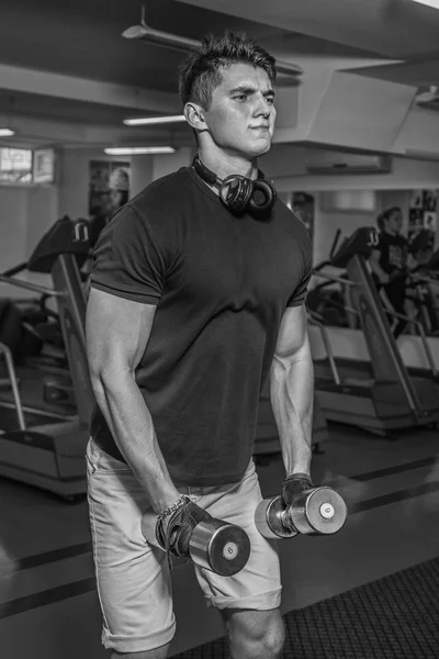 Kroppsbyggare gör tränar med hantlar på gymmet. Arbete på händerna berätta muskler. Ansträngande träning till ett slut. Bilder för idrottsliga tidskrifter och webbplatser. — Stockfoto