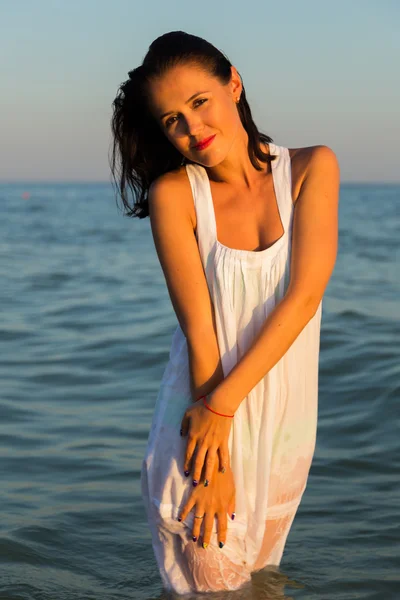 The young beautiful girl in a white dress on the beach. Photo beautiful girl on the beach. Girl posing in seductive manner. Photo for travel and social magazines, posters and websites. — Stock Photo, Image