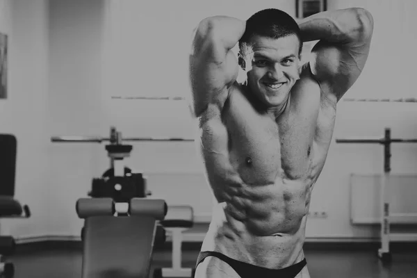 Beau, athlétique, confiant dans la salle de gym. pose de musculation — Photo