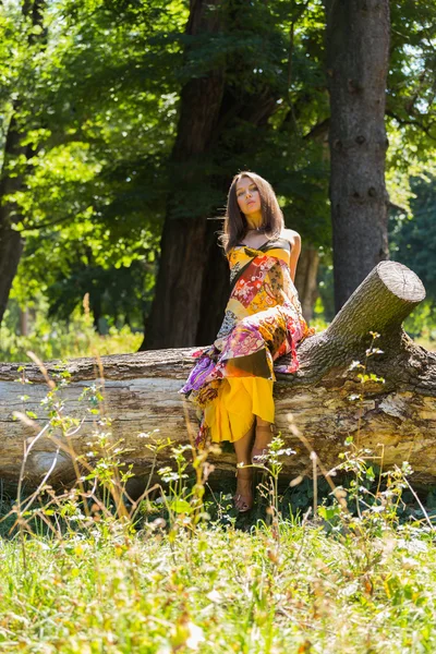 Een jong en aantrekkelijk meisje in mooie zomerse jurk midden van zonnige weide. Vrolijk meisje koesteren in de warme stralen van de zomerzon. Mooi beeld van een zorgeloze meisje. — Stockfoto