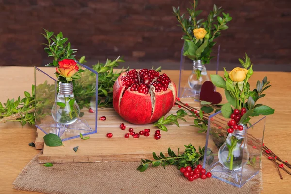 Mooie compositie met granaatappel, bloemen en bollen. — Stockfoto