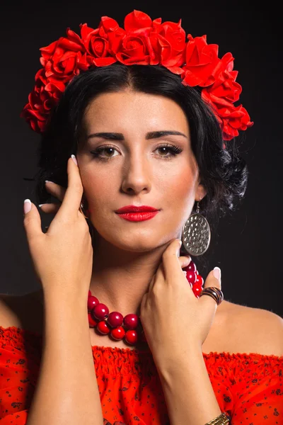 Bella donna sexy in rosso. Bella immagine della ragazza in rosso. Elegante corona di fiori rossi, gioielli alla moda, ritratto di una ragazza . — Foto Stock