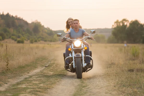 Jeunes mariés au milieu du terrain sur une route de moto. Heureux couple voyageant sur une moto . — Photo