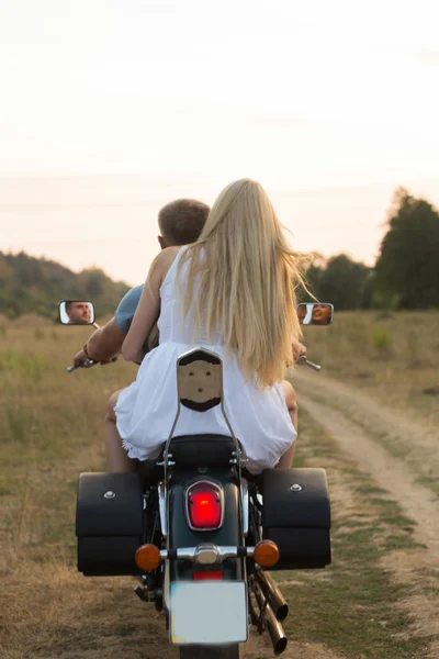 Recém-casados no meio do campo numa estrada de motas. Casal feliz viajando em uma motocicleta . — Fotografia de Stock