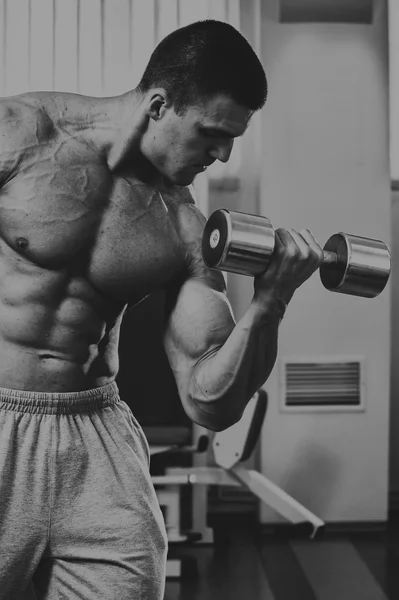 Bodybuilder fait de l'exercice avec des haltères à la salle de gym . — Photo