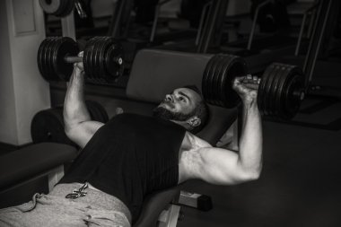 Adam jimnastik salonu. Egzersiz halter kılıyor. Spor, güç, halter, gerginlik, egzersiz - sağlıklı bir yaşam tarzı kavramı. Fitness ve spor hakkında makale.