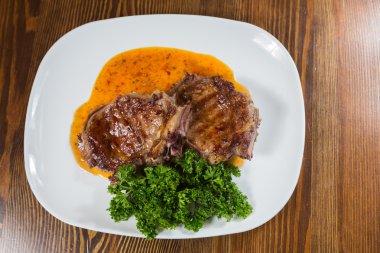 Dana rosto bir tabakta sebze ile bir tavada.