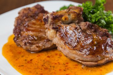 Dana rosto bir tabakta sebze ile bir tavada.