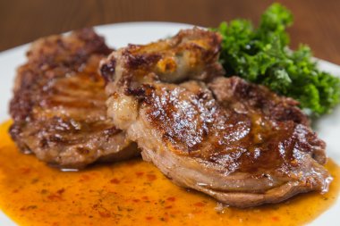 Dana rosto bir tabakta sebze ile bir tavada.