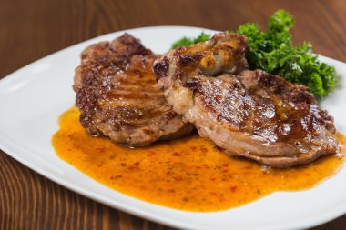 Dana rosto bir tabakta sebze ile bir tavada.