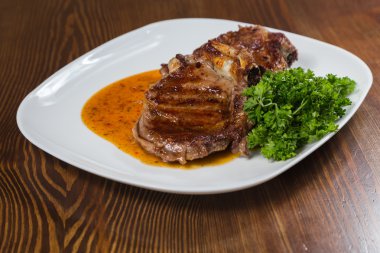 Dana rosto bir tabakta sebze ile bir tavada.