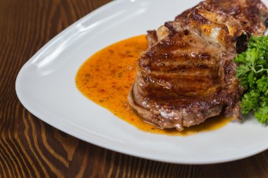 Dana rosto bir tabakta sebze ile bir tavada.