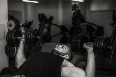 Adam jimnastik salonu. Egzersiz halter kılıyor. Spor, güç, halter, gerginlik, egzersiz - sağlıklı bir yaşam tarzı kavramı. Fitness ve spor hakkında makale.