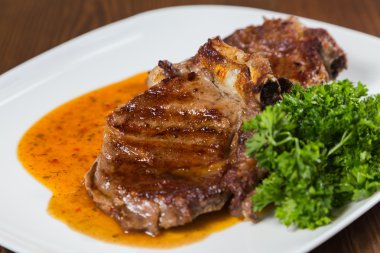 Dana rosto bir tabakta sebze ile bir tavada.