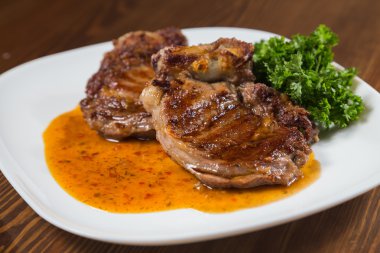 Dana rosto bir tabakta sebze ile bir tavada.