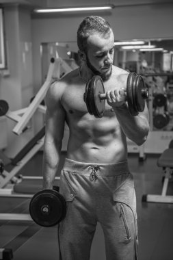 Adam jimnastik salonu. Egzersiz halter kılıyor. Spor, güç, halter, gerginlik, egzersiz - sağlıklı bir yaşam tarzı kavramı. Fitness ve spor hakkında makale.