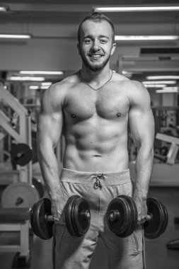 Adam jimnastik salonu. Egzersiz halter kılıyor. Spor, güç, halter, gerginlik, egzersiz - sağlıklı bir yaşam tarzı kavramı. Fitness ve spor hakkında makale.