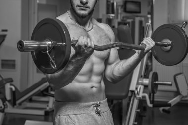 Kaslı adam spor salonunda ağırlık ile çalışma dışarı. Adam egzersizleri yapar.