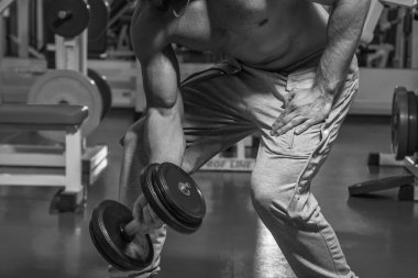 Adam jimnastik salonu. Egzersiz halter kılıyor. Spor, güç, halter, gerginlik, egzersiz - sağlıklı bir yaşam tarzı kavramı. Fitness ve spor hakkında makale.