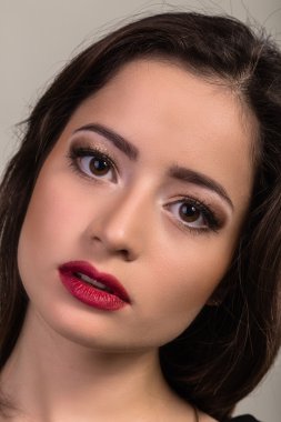 Karanlık bir arka plan üzerinde güzel genç esmer. Seksi seksi esmer. Lüks kadın şık makyaj ile.