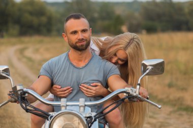 Bir motosiklet üzerinde bir alanda genç Romantik Çift