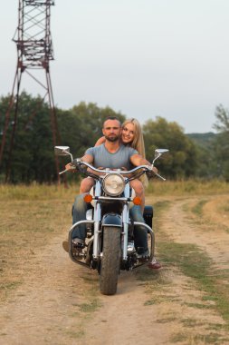 Bir motosiklet üzerinde bir alanda genç Romantik Çift