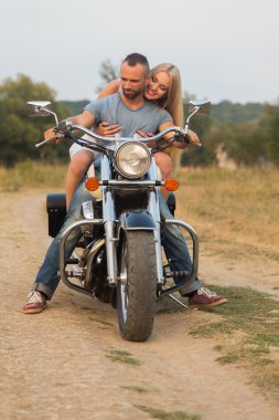 Bir motosiklet üzerinde bir alanda genç Romantik Çift